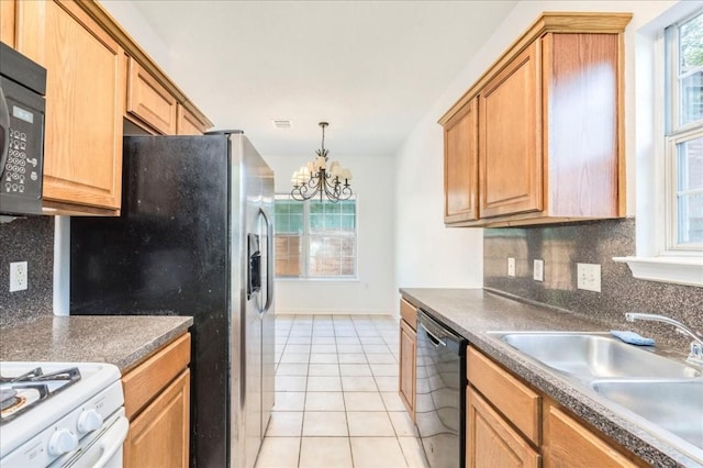 kitchen with light tile patterned floors, a wealth of natural light, black appliances, and sink