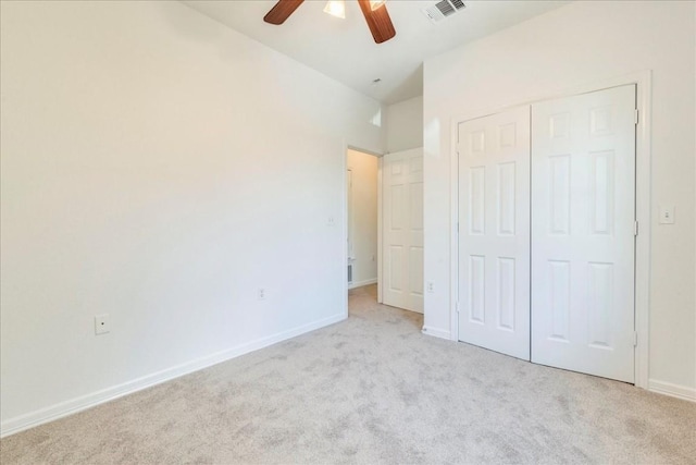 unfurnished bedroom featuring light colored carpet, ceiling fan, and a closet