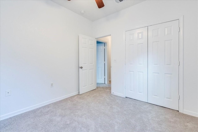 unfurnished bedroom featuring light carpet, ceiling fan, and a closet