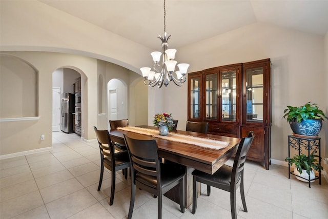 tiled dining area with lofted ceiling and a notable chandelier