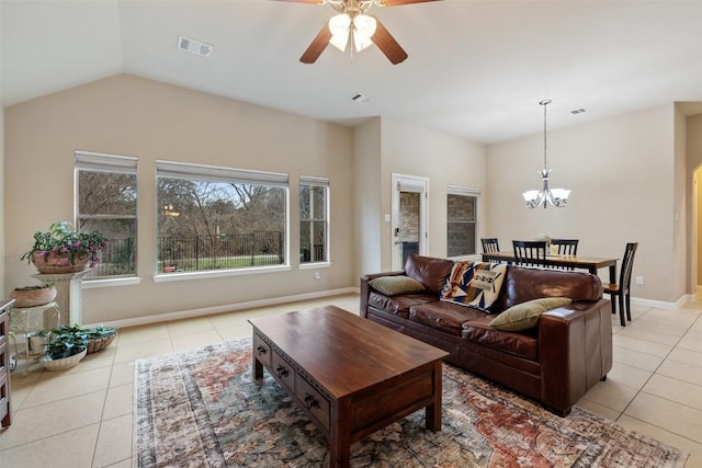 living room featuring lofted ceiling, ceiling fan with notable chandelier, and light tile patterned floors