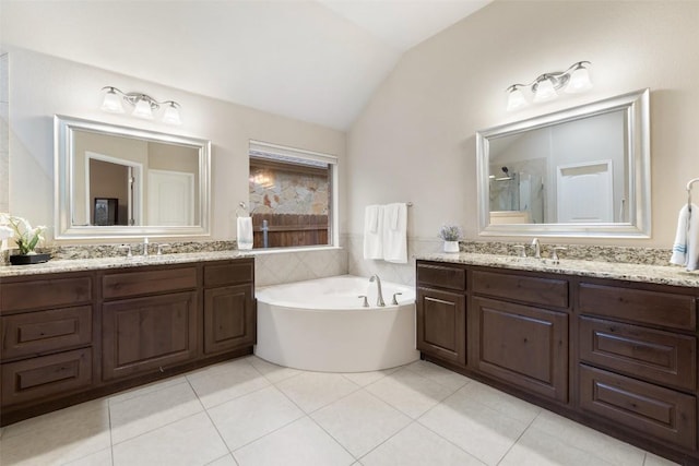 bathroom featuring vaulted ceiling, shower with separate bathtub, vanity, and tile patterned floors