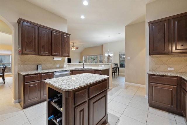 kitchen featuring sink, decorative light fixtures, stainless steel dishwasher, kitchen peninsula, and a kitchen island