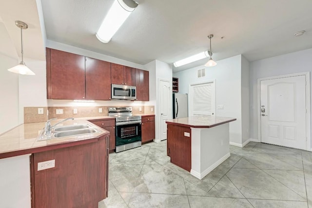 kitchen featuring sink, light tile patterned flooring, hanging light fixtures, and appliances with stainless steel finishes