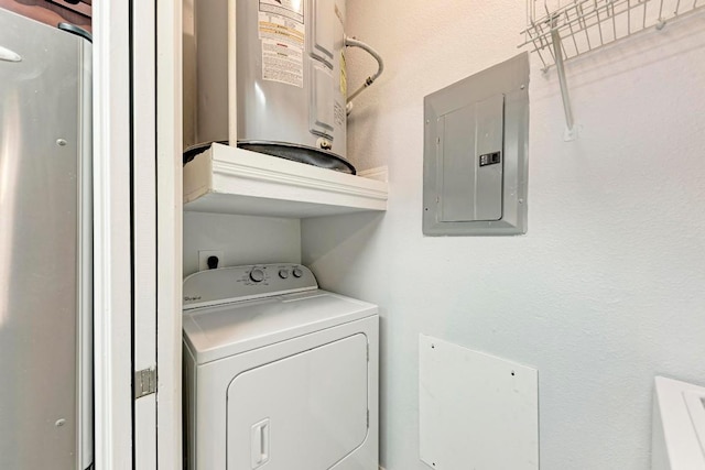 clothes washing area featuring electric panel, washer / dryer, and water heater