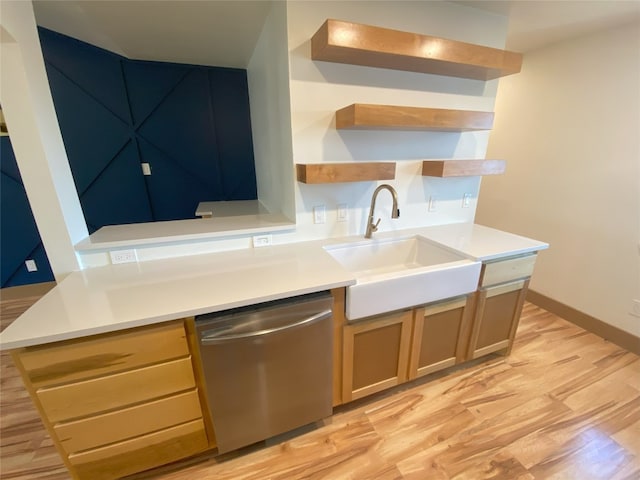 kitchen featuring sink, stainless steel dishwasher, and light wood-type flooring