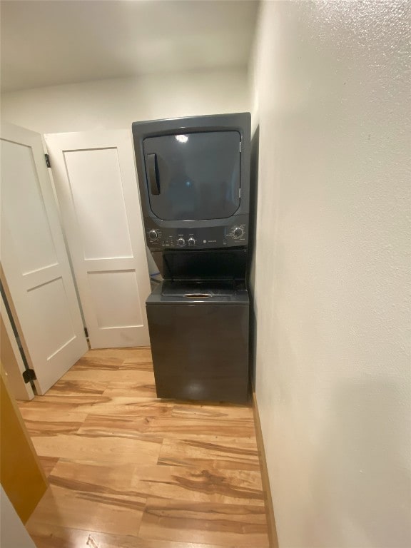 interior space featuring stacked washing maching and dryer and light wood-type flooring