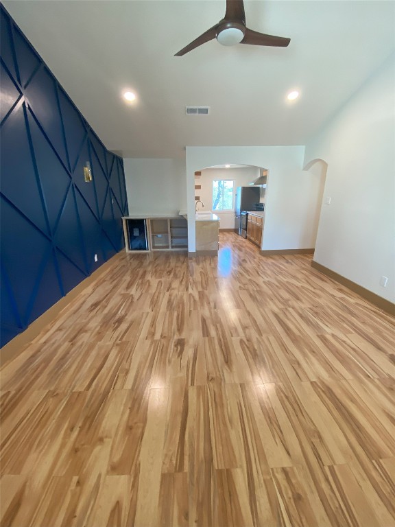 interior space with ceiling fan and light hardwood / wood-style floors