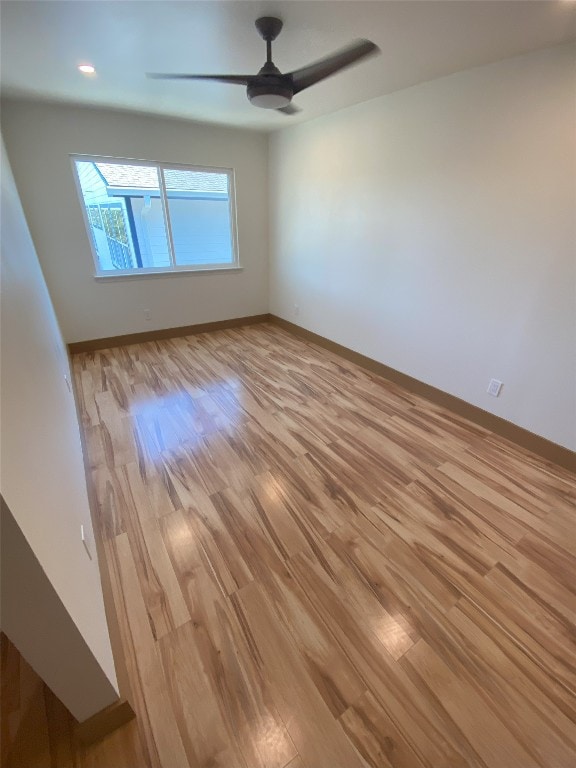 empty room with light hardwood / wood-style flooring and ceiling fan