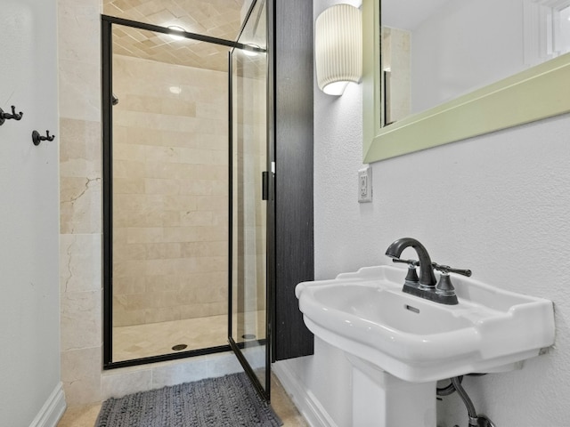 bathroom featuring sink and a shower with door