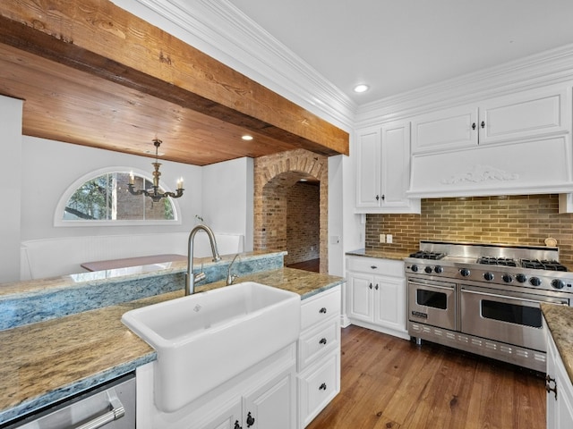 kitchen featuring sink, custom exhaust hood, decorative light fixtures, stainless steel appliances, and white cabinets