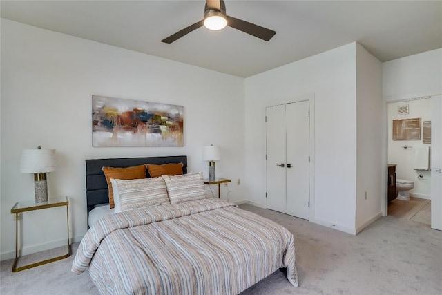 carpeted bedroom featuring a closet, ceiling fan, and ensuite bathroom