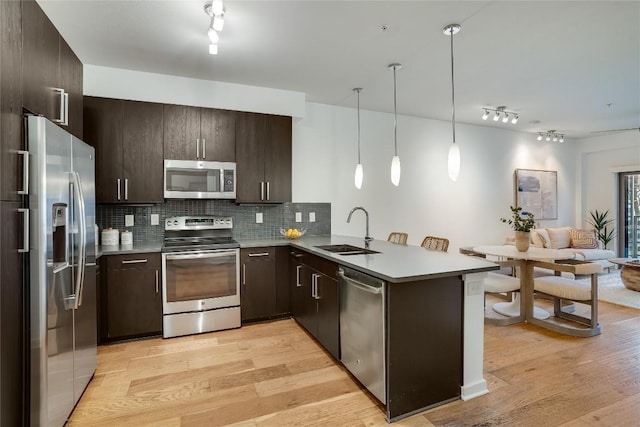 3600 S Lamar Blvd Unit 115, Austin, TX 78704 - kitchen featuring stainless steel appliances, a peninsula, track lighting, and a sink