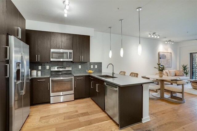 3600 S Lamar Blvd Unit 115, Austin, TX 78704 - kitchen with appliances with stainless steel finishes, a sink, a peninsula, and track lighting