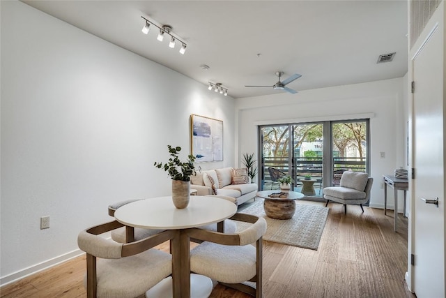 living room featuring ceiling fan, track lighting, and light hardwood / wood-style flooring