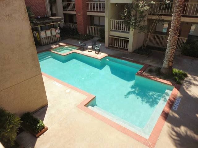 view of swimming pool featuring a patio and a hot tub