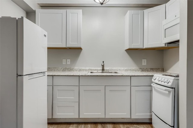 kitchen featuring light stone counters, white appliances, sink, and white cabinets