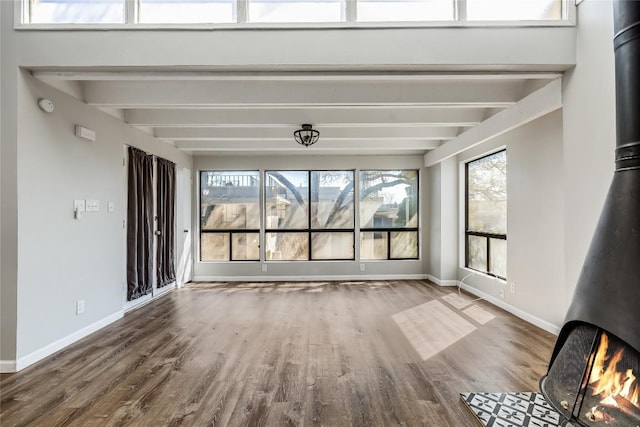 interior space featuring beam ceiling and a wood stove