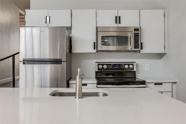 kitchen featuring sink, white cabinets, and appliances with stainless steel finishes