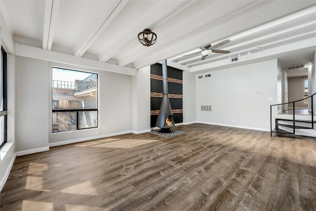 unfurnished living room featuring beam ceiling, wood-type flooring, and ceiling fan