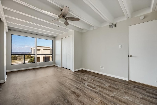 empty room featuring dark hardwood / wood-style floors, ceiling fan, and beam ceiling