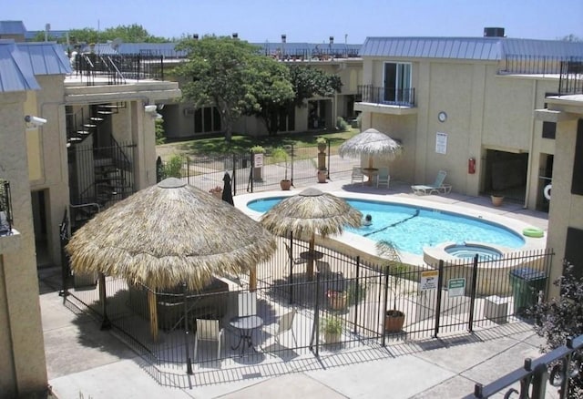 view of swimming pool with a hot tub and a patio