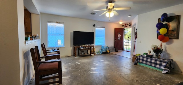 living room featuring concrete flooring and ceiling fan