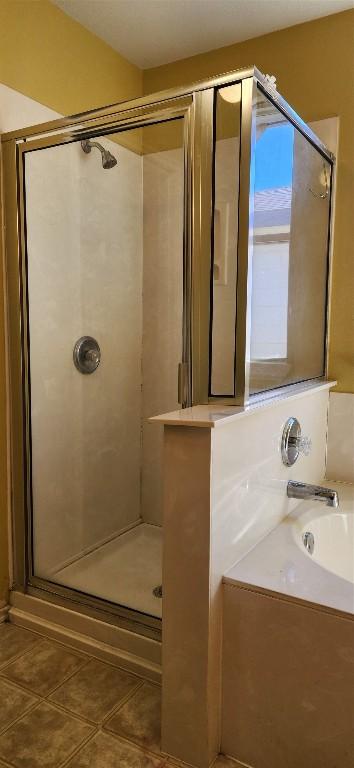 bathroom with tile patterned flooring and separate shower and tub