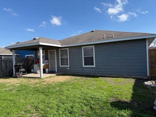 rear view of property featuring a yard and a patio area