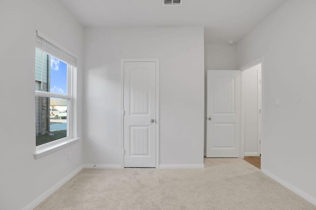 unfurnished bedroom featuring light carpet