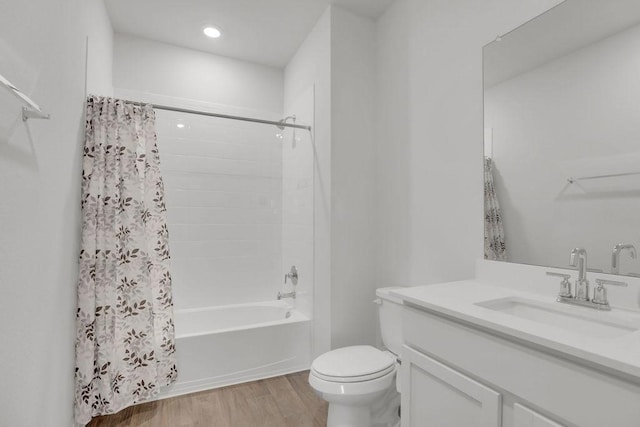 full bathroom with vanity, hardwood / wood-style floors, shower / bath combination with curtain, and toilet