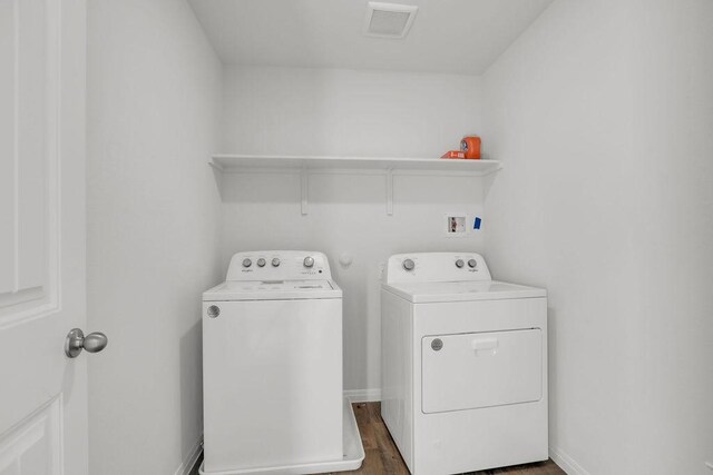 laundry area featuring dark hardwood / wood-style floors and washing machine and clothes dryer