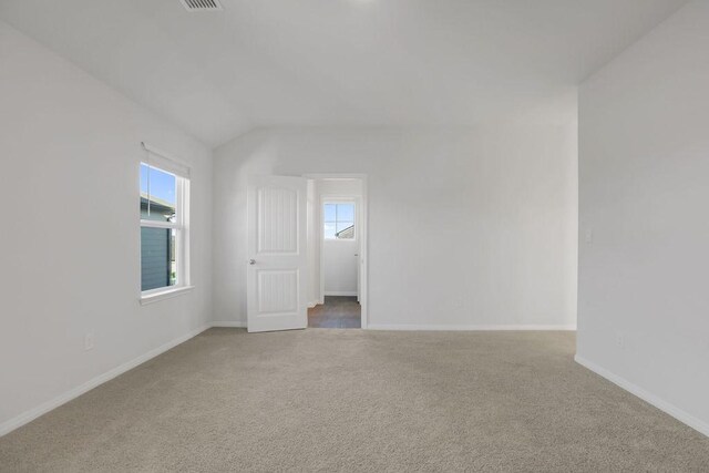 unfurnished room with carpet floors and vaulted ceiling