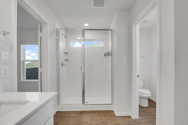 bathroom with vanity, hardwood / wood-style floors, toilet, and walk in shower