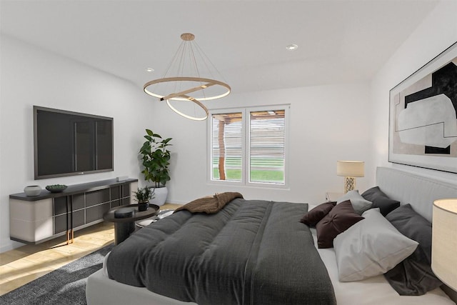 bedroom featuring wood-type flooring and an inviting chandelier