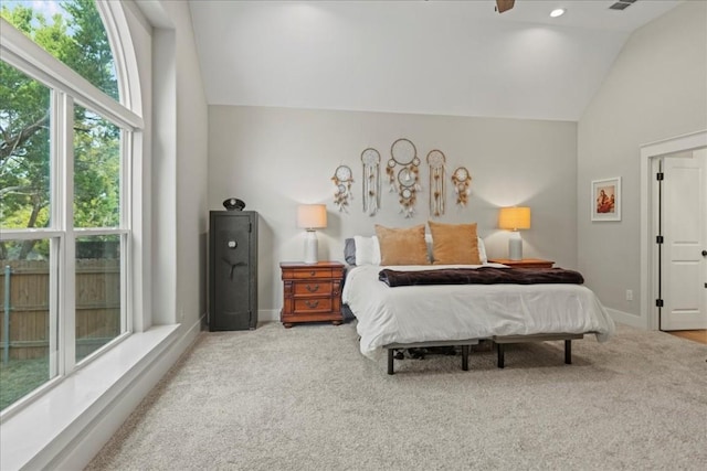 carpeted bedroom with ceiling fan, vaulted ceiling, and multiple windows