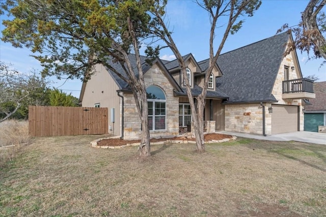 view of front of house featuring a garage, a front yard, and a balcony