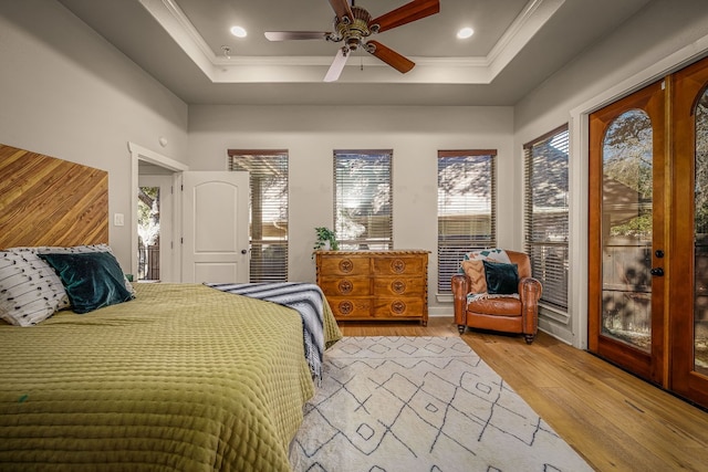 bedroom with a tray ceiling, access to exterior, ceiling fan, light hardwood / wood-style floors, and crown molding