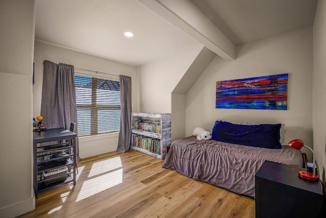 bedroom featuring hardwood / wood-style floors and vaulted ceiling with beams