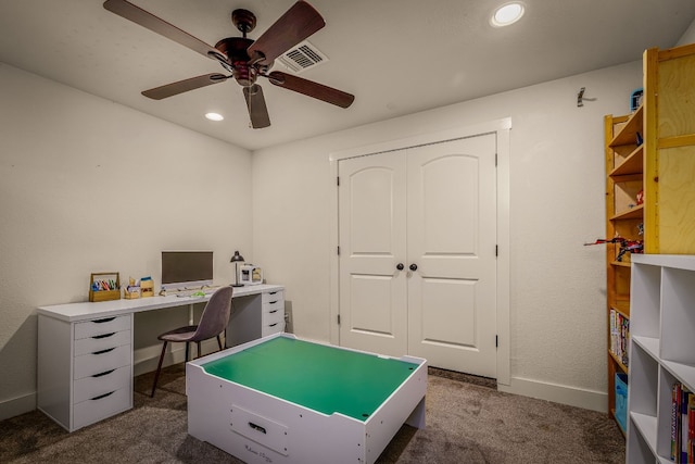 game room with ceiling fan and dark colored carpet