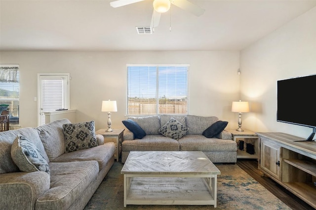 living room with plenty of natural light, dark wood-type flooring, and ceiling fan