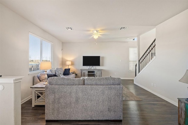 living room featuring dark wood-type flooring and ceiling fan