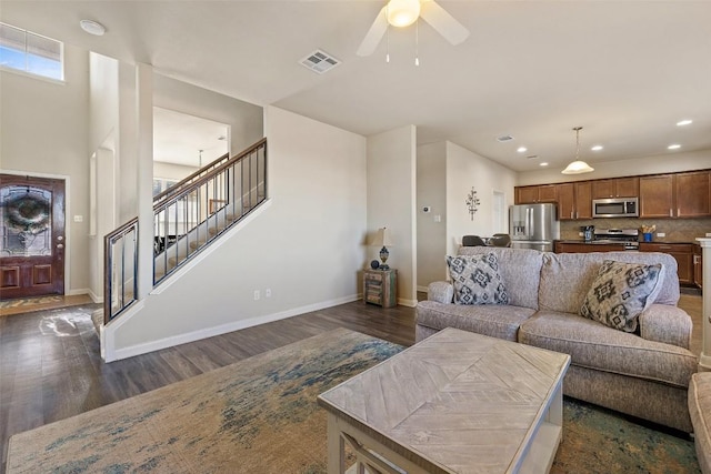 living room featuring dark wood-type flooring and ceiling fan