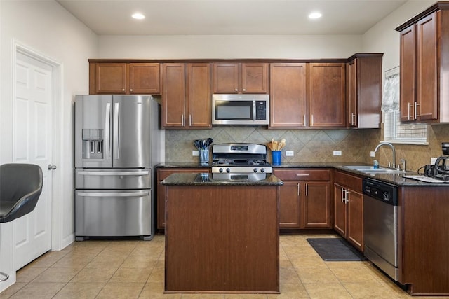 kitchen featuring dark stone countertops, light tile patterned flooring, a center island, and appliances with stainless steel finishes