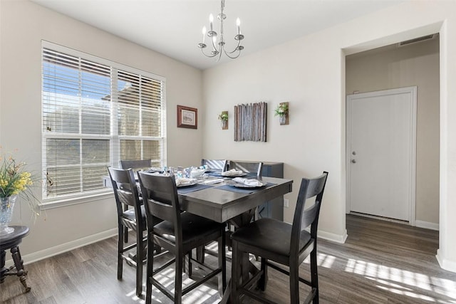 dining area featuring hardwood / wood-style floors and an inviting chandelier