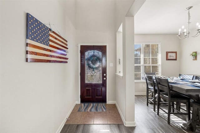 foyer entrance featuring dark wood-type flooring and a chandelier