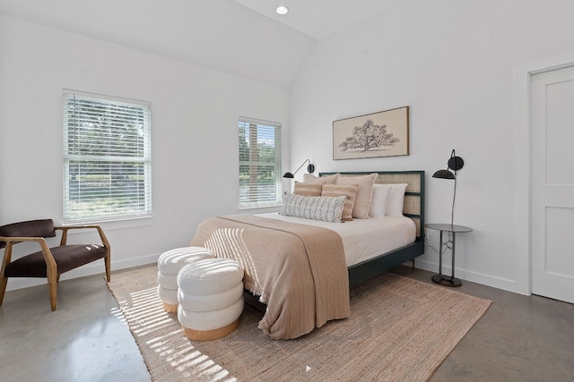 bedroom with concrete flooring and vaulted ceiling