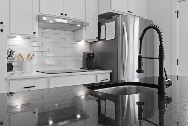 kitchen with white cabinetry, dark stone countertops, backsplash, and black electric cooktop