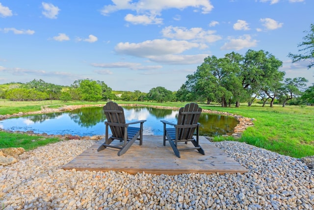 view of dock with a water view and a lawn