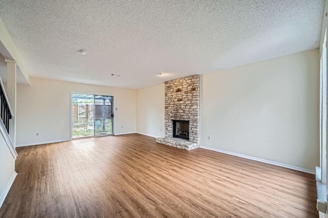 unfurnished living room featuring wood-type flooring, a fireplace, and a textured ceiling